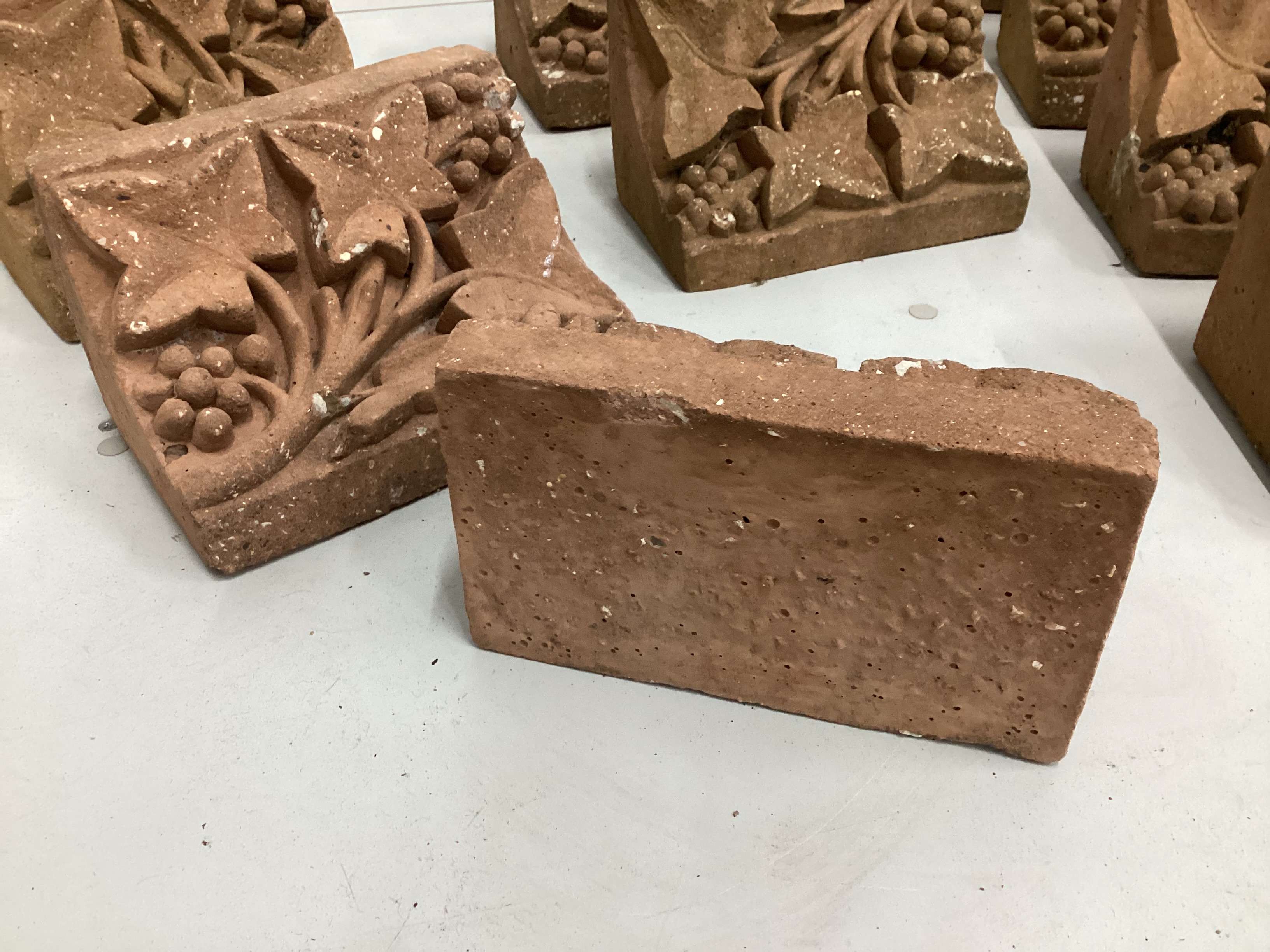 A set of ten cast terracotta fruiting vine corbels, each 23cm wide, depth 15cm, height 13cm